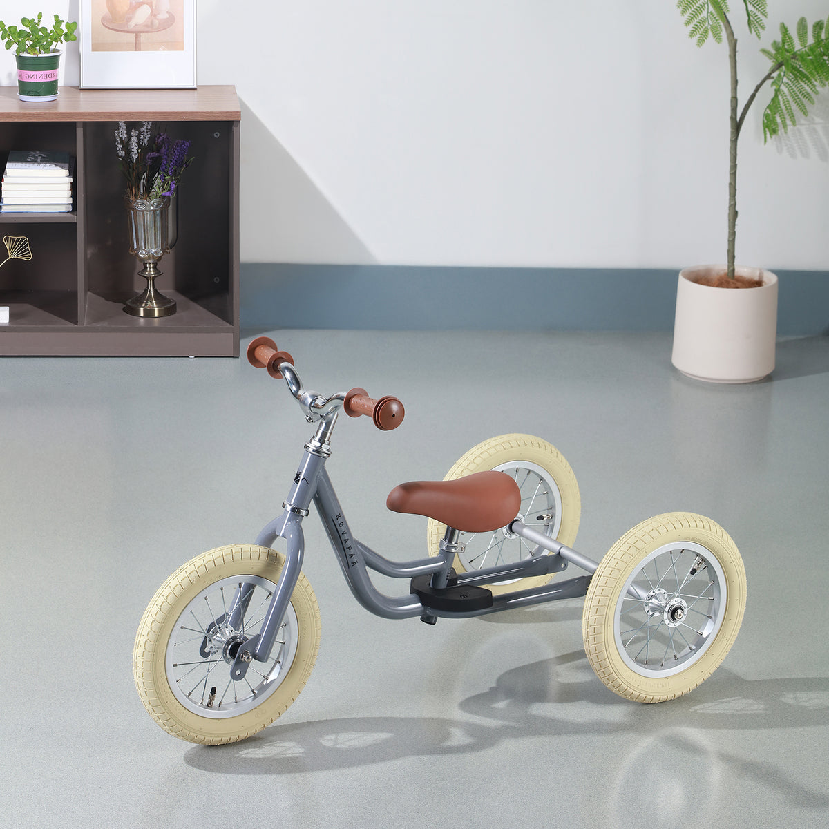 Køvapää grijze 2-in-1 loopfiets in huiselijke setting gefotografeerd