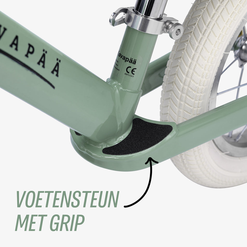 close-up van voetensteun op groene Køvapää loopfiets