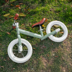 groene Køvapää loopfiets buiten in het gras gefotografeerd