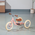 Kovapää 2 in 1 Loopfiets Roze in een moderne ruimte met houten meubelen.