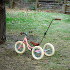 Roze Køvapää 2-in-1 loopfiets buiten in het gras gefotografeerd